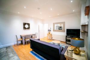 a living room with a couch and a table at Stay with Serena Homes , One bedroom apartment in Purley