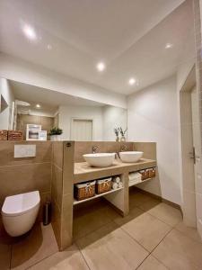 a bathroom with two sinks and a toilet at Stilvolles Ferienhaus in Gerolstein in Gerolstein