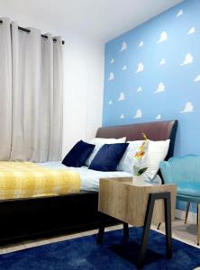1 dormitorio con 1 cama y una pared azul con nubes en Stylish and Unique Bedroom In Gateshead - Close To Newcastle en Sheriff Hill