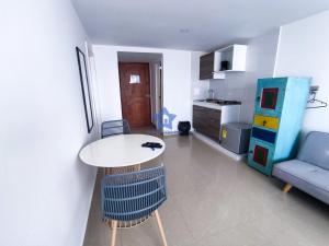 sala de estar con mesa y sofá azul en Aparta Estudio Vista Piso 20, en Cartagena de Indias
