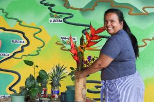 una mujer de pie junto a un jarrón de flores en Mano Verde Minca en Minca