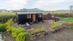 a tiny house in the middle of a garden at Carlingford Glamping Hut 