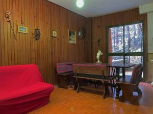 uma sala de estar com uma mesa e um sofá vermelho em Casa San Rocco em Roccaraso