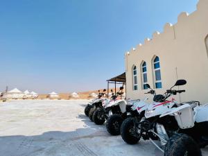 una fila de motocicletas estacionadas al lado de un edificio en Dream Desert Camp 