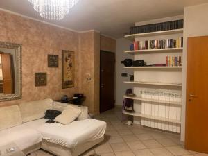 a living room with a white couch and bookshelves at San Lorenzo 66 in San Giovanni Valdarno
