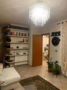 sala de estar con lámpara de araña y habitación con sofá en San Lorenzo 66, en San Giovanni Valdarno