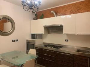 a kitchen with white cabinets and a glass table at San Lorenzo 66 in San Giovanni Valdarno