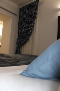 uma cama com uma almofada azul num quarto com uma janela em GeLiRó Apartment Catania Centro em Catânia