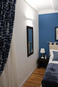 um quarto com uma cama e uma parede azul em GeLiRó Apartment Catania Centro em Catânia