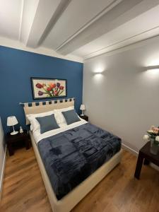 um quarto com uma cama com uma parede azul em GeLiRó Apartment Catania Centro em Catânia