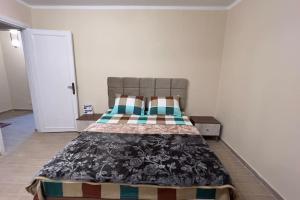 um quarto com uma cama com um cobertor em Modern and cozy apartment no Cairo