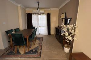 comedor con mesa y sillas verdes en Modern and cozy apartment, en El Cairo