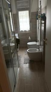 bagno con 2 lavandini, servizi igienici e finestra di Zena a Genova