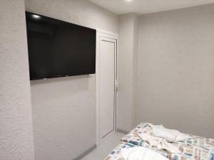 a bedroom with a flat screen tv on the wall at Downtown in Ruse