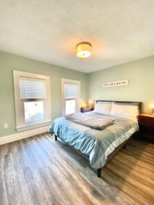 a bedroom with a bed and two windows at Cozy Suite-Walk to the Falls! in Niagara Falls