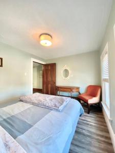 a bedroom with a large bed and a chair at Cozy Suite-Walk to the Falls! in Niagara Falls