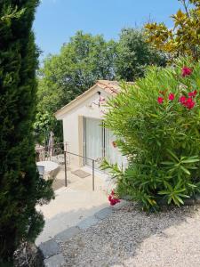 une petite maison blanche avec une brousse devant elle dans l'établissement Appart13 piscine chauffée de luxe Belvoir13 à 10 min d Aix, à Aix-en-Provence