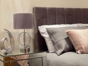 uma cama com uma mesa com um candeeiro e almofadas em Camden Elegance : Cozy&Modern (10 min to center) em Londres