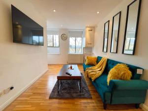 uma sala de estar com um sofá azul e uma mesa de centro em Camden Elegance : Cozy&Modern (10 min to center) em Londres