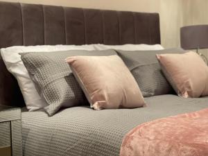 uma cama com um monte de almofadas em Camden Elegance : Cozy&Modern (10 min to center) em Londres