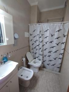 a bathroom with a toilet and a shower curtain with bats at Namoro alojamientos in Mar del Plata