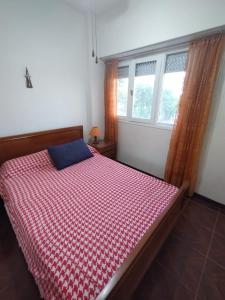 a bedroom with a bed with a red and white checkered blanket at Namoro alojamientos in Mar del Plata