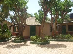 a building with trees in front of it at Camping-Sukuta & Lodge in Sukuta