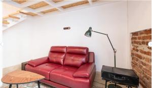 a red leather couch in a living room with a lamp at Casa Guadalupe y Roque in Santa Cruz de Tenerife