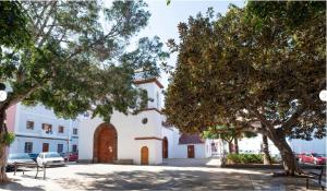 a building with a gate and trees in a parking lot at Casa Guadalupe y Roque in Santa Cruz de Tenerife