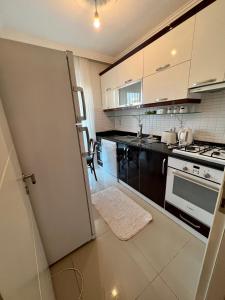 a kitchen with black and white appliances and a door at Entire house 2 bedrooms, 1 dbl 1 bunk bed, private garden, pool and secure in Antalya