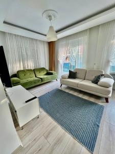 a living room with a couch and a table at Entire house 2 bedrooms, 1 dbl 1 bunk bed, private garden, pool and secure in Antalya