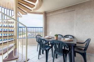 jadalnia ze stołem i krzesłami oraz balkonem w obiekcie Patacona Penthouse SeaView w Walencji