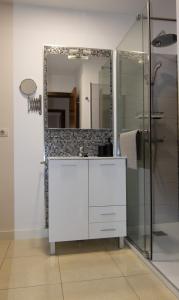 Un baño con un tocador blanco y un espejo. en Vivienda vacacional Rous, en Los Llanos de Aridane