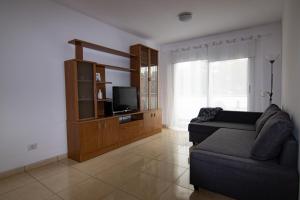 a living room with a couch and a flat screen tv at Vivienda vacacional Rous in Los Llanos de Aridane