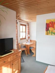 沃爾特湖的住宿－Pension am See，客厅配有平面电视和桌子。