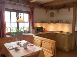 een keuken met een tafel en een keuken met een fornuis bij Pension am See in Wörthsee