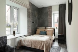 Un dormitorio con una cama y dos ventanas. en Koralas, en Klaipėda