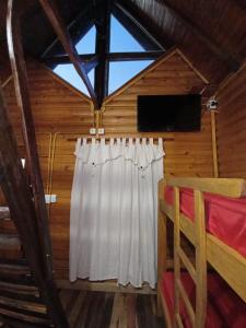 Habitación con cama y ventana en una cabaña en Cabañas Misioneras en San Ignacio