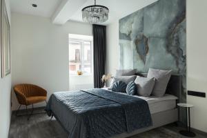 1 dormitorio con 1 cama con una pintura en la pared en Koralas en Klaipėda