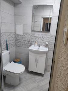 a white bathroom with a toilet and a sink at Downtown in Ruse