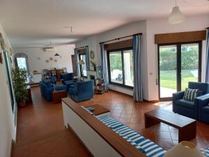 sala de estar con sillas azules y sofá en Villa Azevedo en Vilamoura