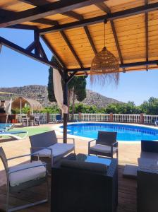 un patio con sillas y una piscina en Los Naranjos, en Alcaucín