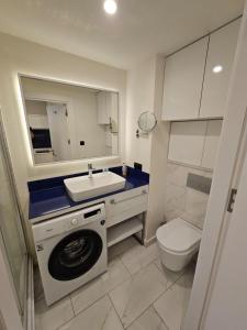een badkamer met een wasmachine en een wastafel bij Sea View Lux Aparthotel in ORBi City Batumi in Batoemi