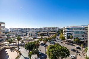 una vista aérea de una ciudad con palmeras y edificios en Apartamento Puerto Banús con Parking & piscina., en Marbella