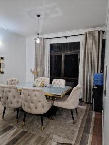 a dining room with a table and some chairs at 3 BDR Luxurious Villa in Milimani Kisumu in Kisumu