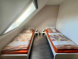two beds in a small room with a window at Schöne Ferienwohnung im Grünen in Hainichen