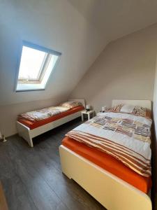 a attic bedroom with two beds and a window at Schöne Ferienwohnung im Grünen in Hainichen