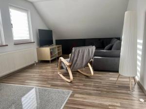 a living room with a chair and a couch at Schöne Ferienwohnung im Grünen in Hainichen