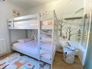 1 dormitorio con 2 literas y un mural de árboles en Grand T3- pied des pistes-63 m2-8 personnes, en La Toussuire