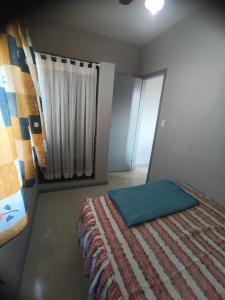 a bedroom with a bed with a green pillow on it at Jardim das orquideas 2 in Rio das Ostras